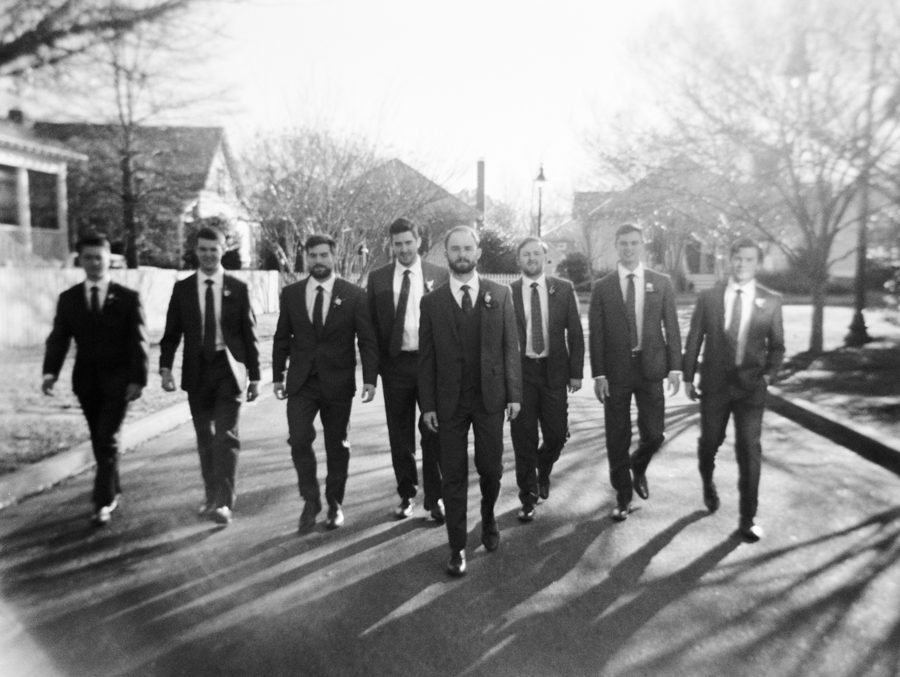 black and white image of groomsmen walking towards the camera at winter wedding in oxford, mississippi