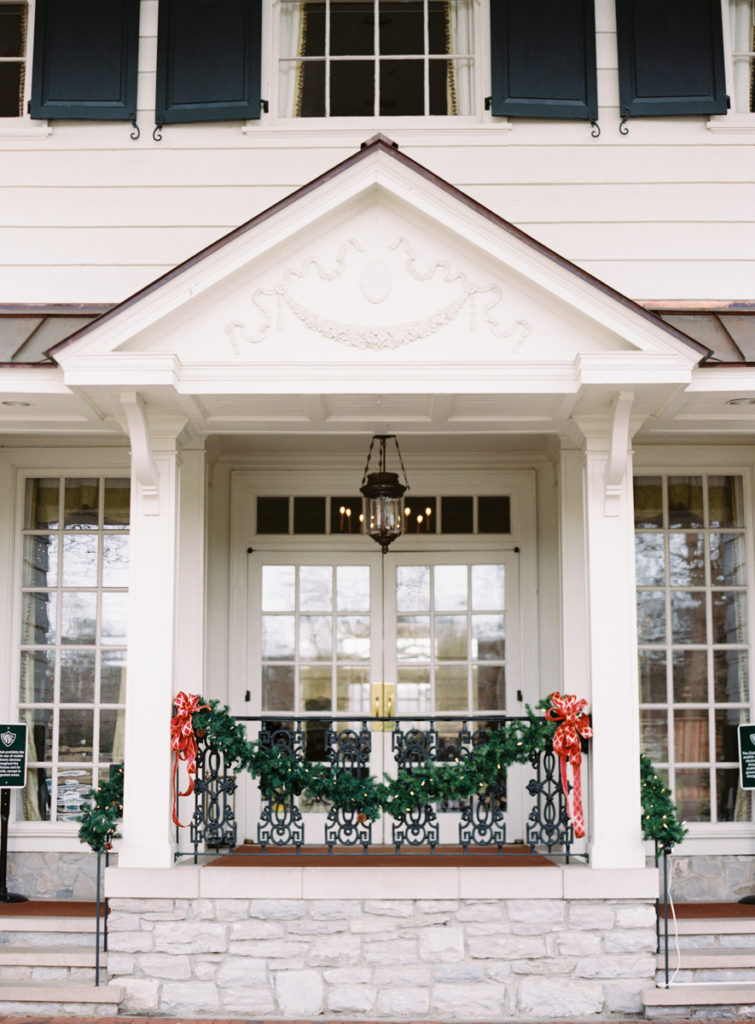 the front of belle meade country club in nashville, tn decorated for winter wedding
