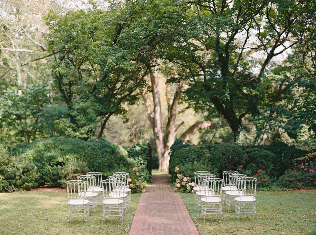 intimate ceremony setup outdoors with modern timeless wedding gown with veil cape at Meadowlark 1939 intimate wedding venue in Atlanta, Georgia shot by film wedding photographer Abigail Lewis Photography 